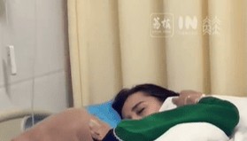 女子下班后到医院陪护母亲，疲惫趴在床边睡去，母亲轻拍其后背